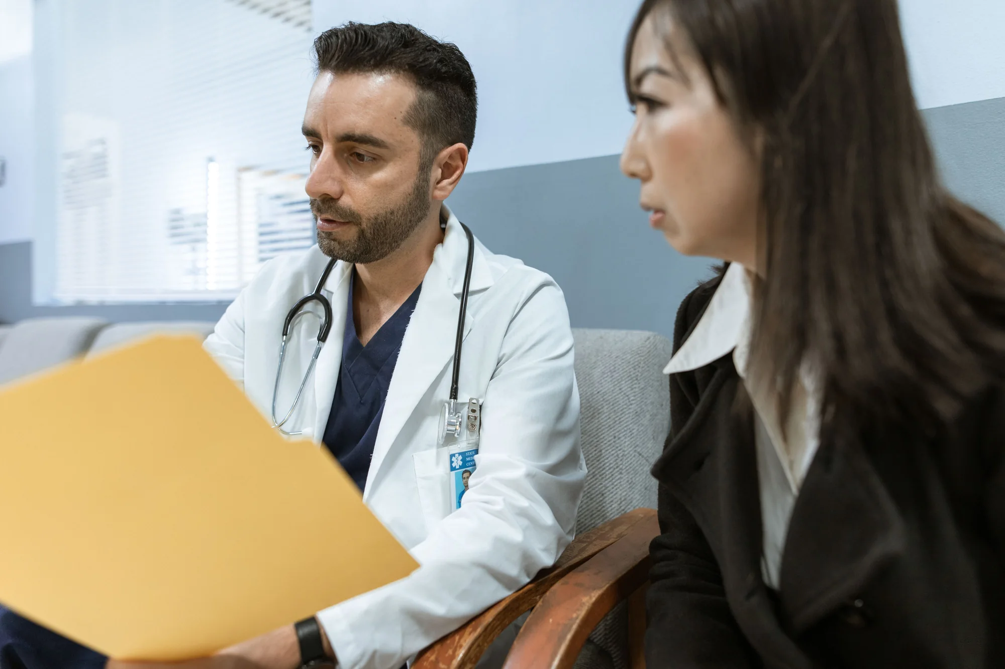 Especialista conversa con una paciente durante una evaluación antes de un tratamiento de contorno de ojos